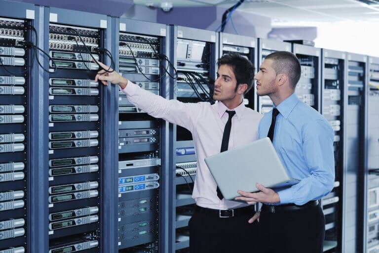 Two men in a server room with some computers