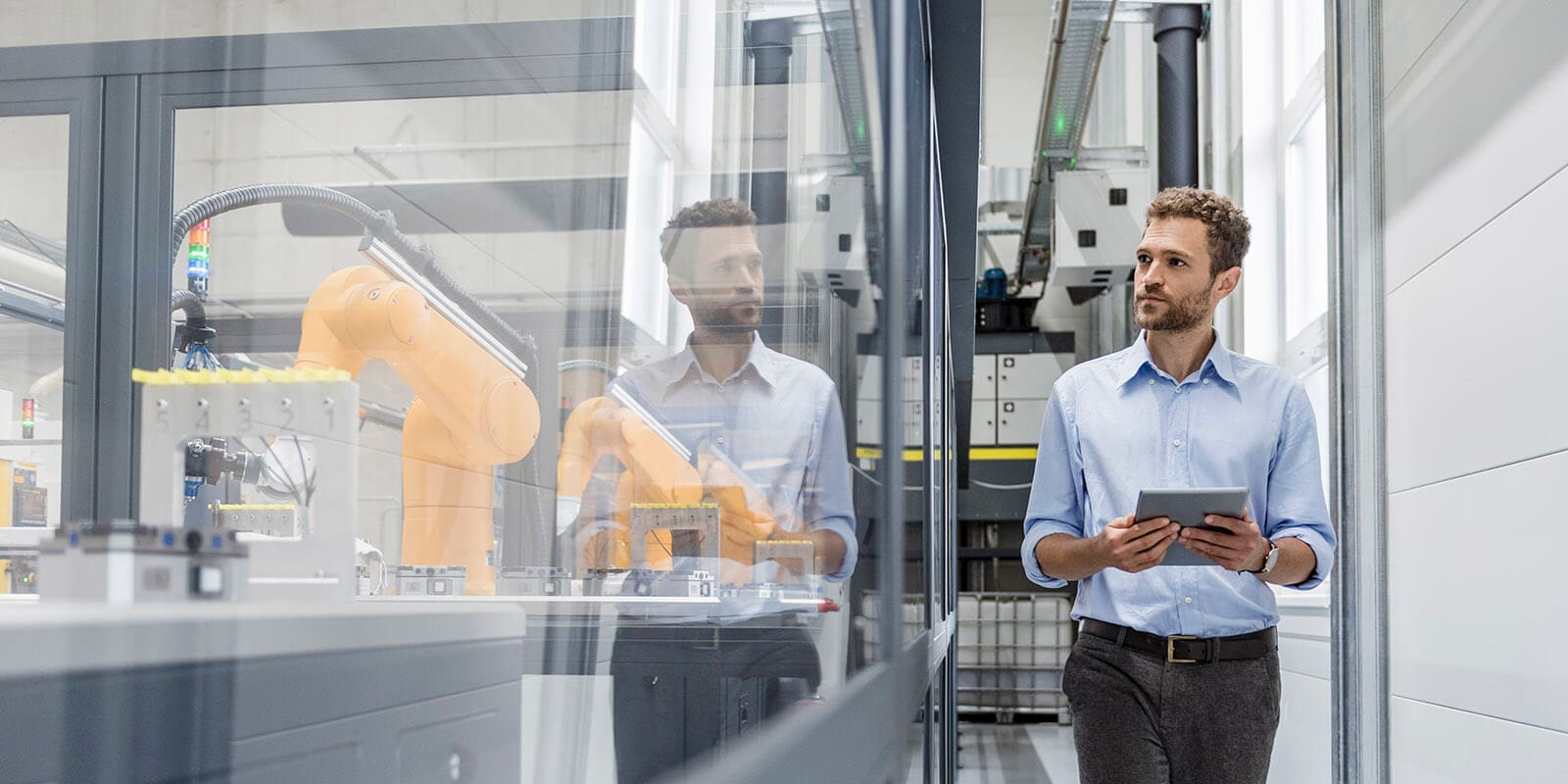 Two men in a factory looking at something on their phone.