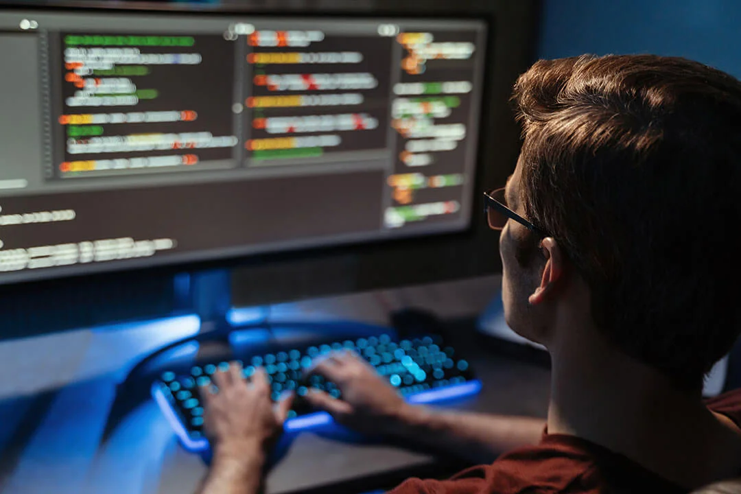 Man coding on a computer at night.