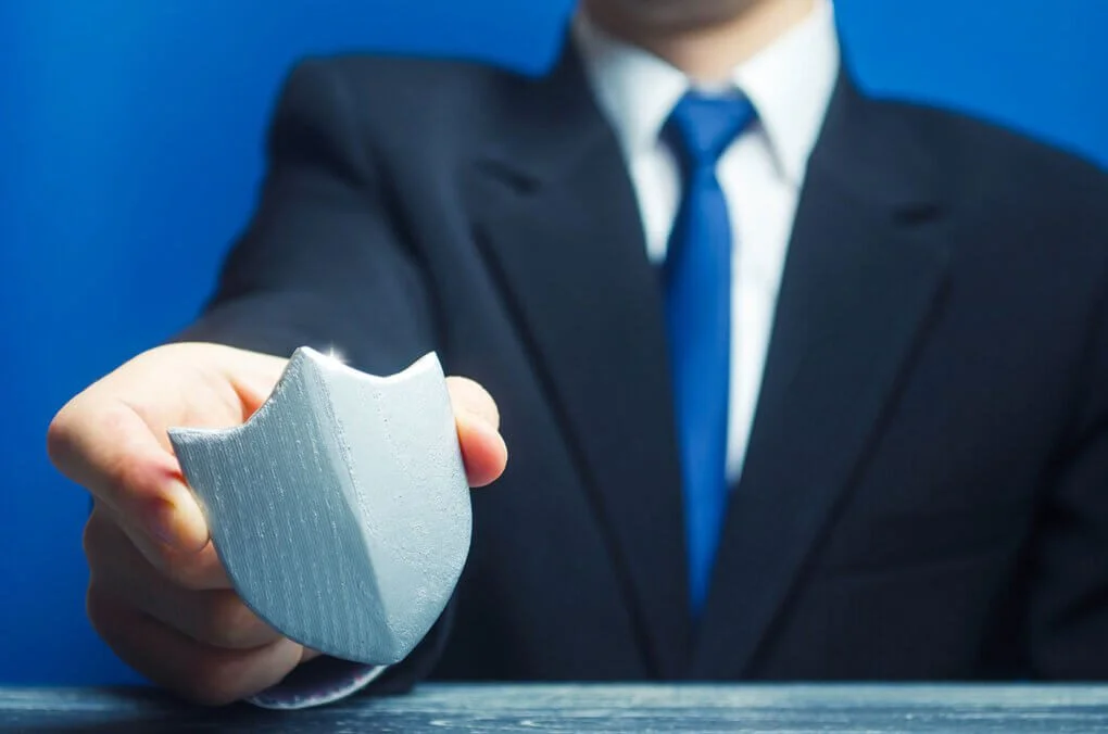 Businessman offering silver shield protection.