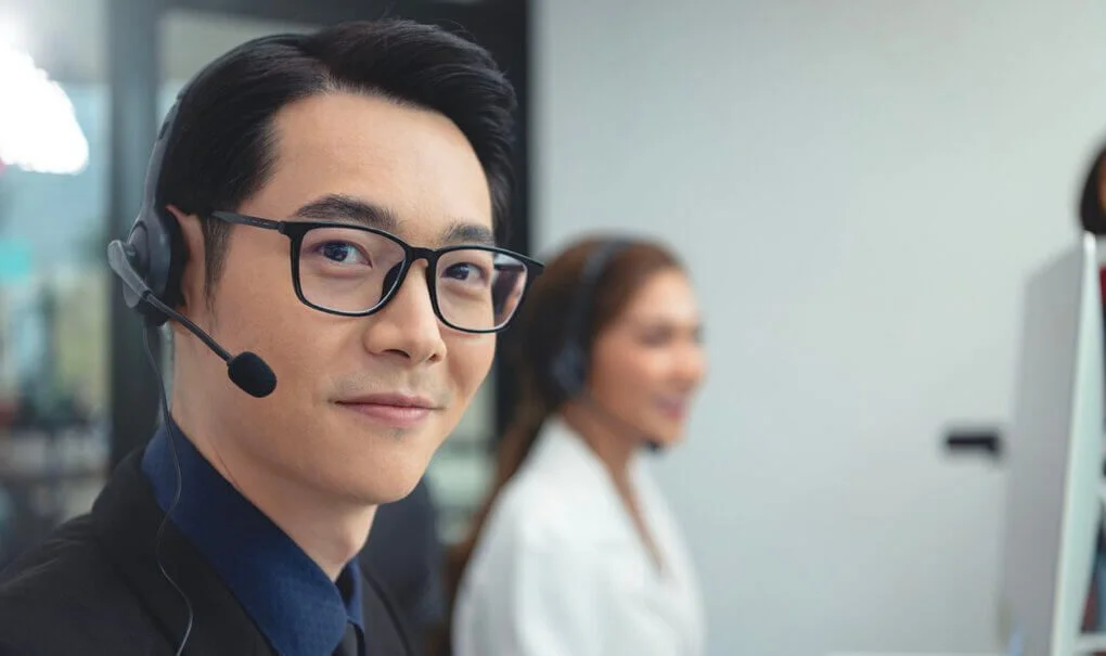 Man wearing glasses and headset in office.