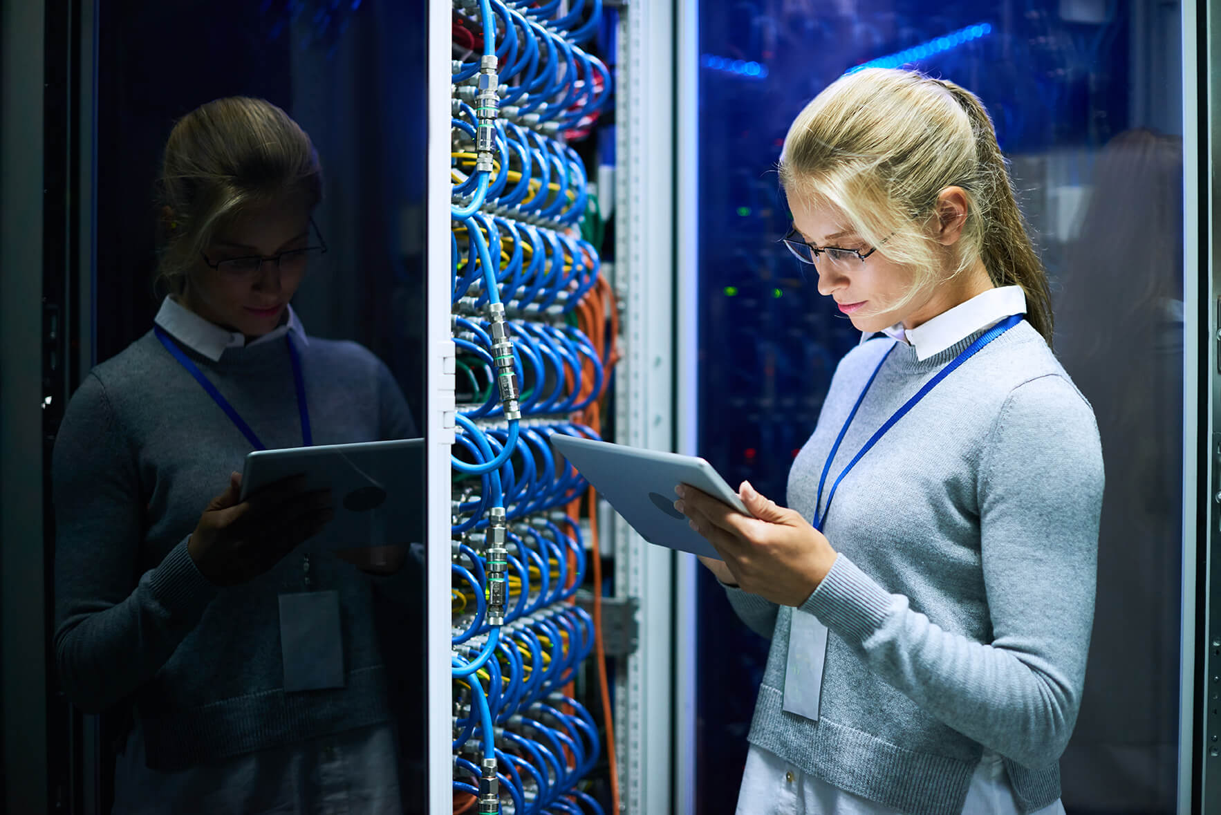 Woman using tablet in server room.