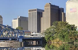 A city skyline with a bridge and river.